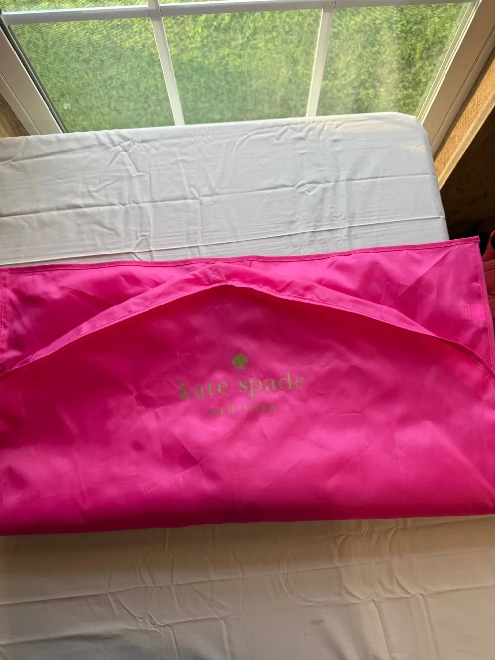 kate spade hot pink garment bag with gold logo